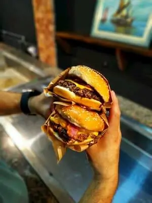 Two burgers being held together